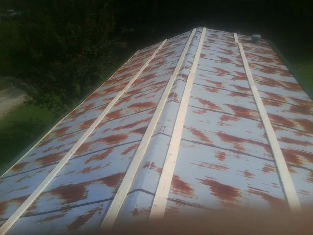 Rusted metal roof panels with new wood purlins before replacement — Storm Damage Roof Repair in Bracey by Roofing Brothers