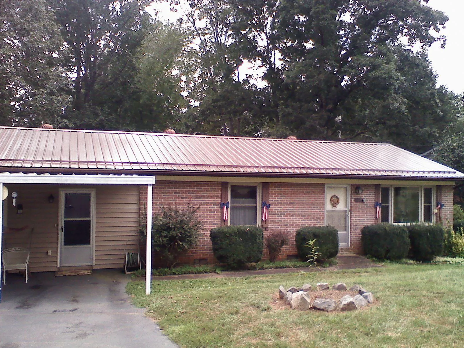 Bronze metal roof and carport on a brick ranch home — Roof Repair work by our crew in Bracey