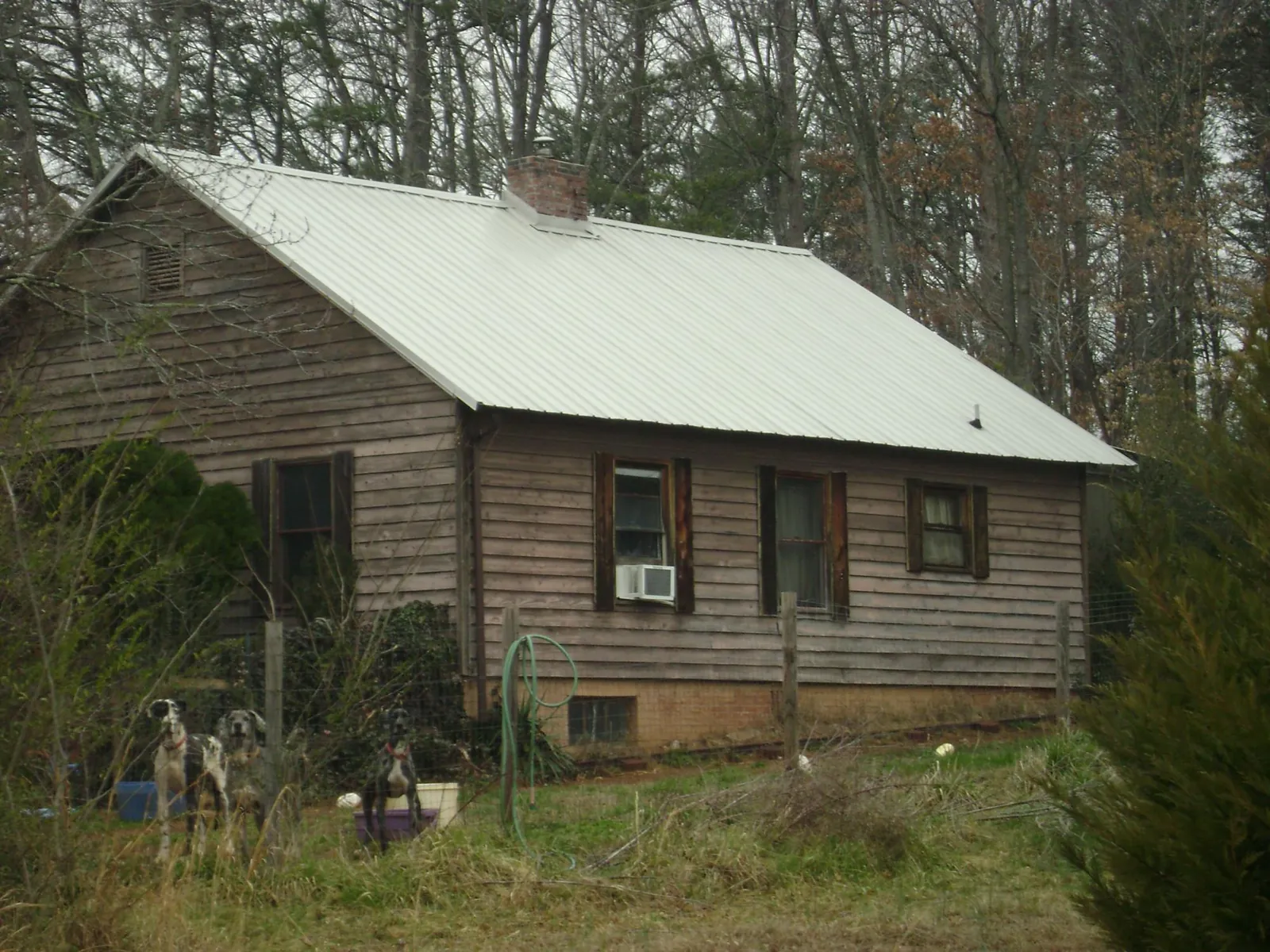 White metal roof on an old wood sided farmhouse, from a Metal Roof Installation job in Bracey